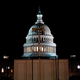 A surveillance camera sits just outside a fence surrounding the capitol building.